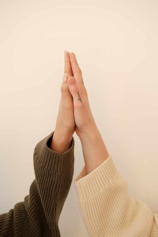 Two Female Hands in Sleeves Doing High Five